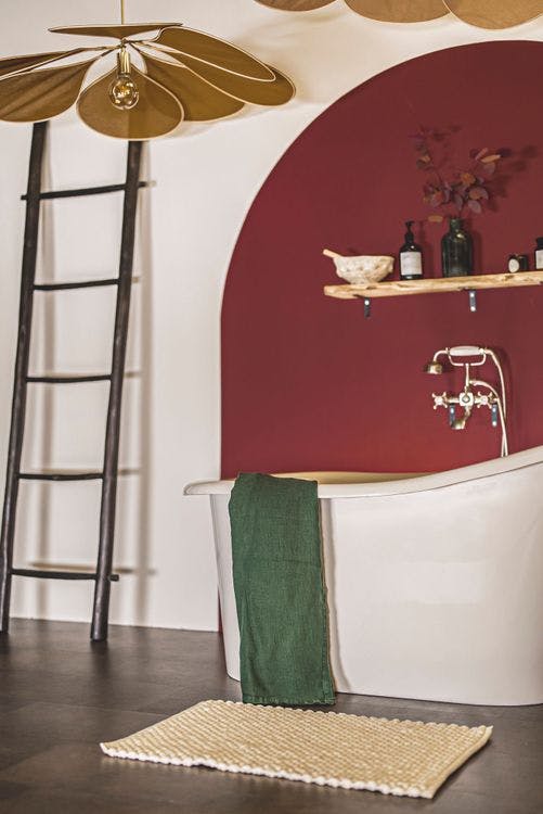 salle de bain tapis de bain sol béton ambré baignoire mur rouge brun beige cassé échelle 